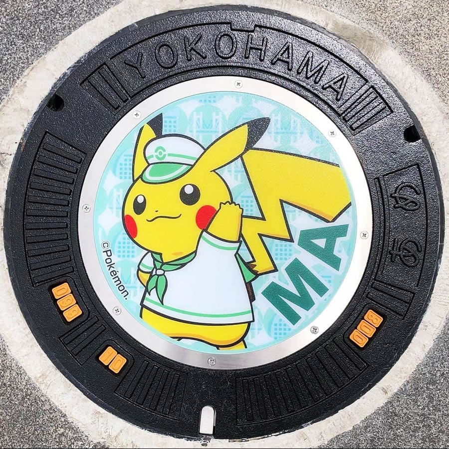 PokéPlak avec Pikachu matelot et le Yo de Yokohama sur un fond vert à motifs de pont et de d'immeuble